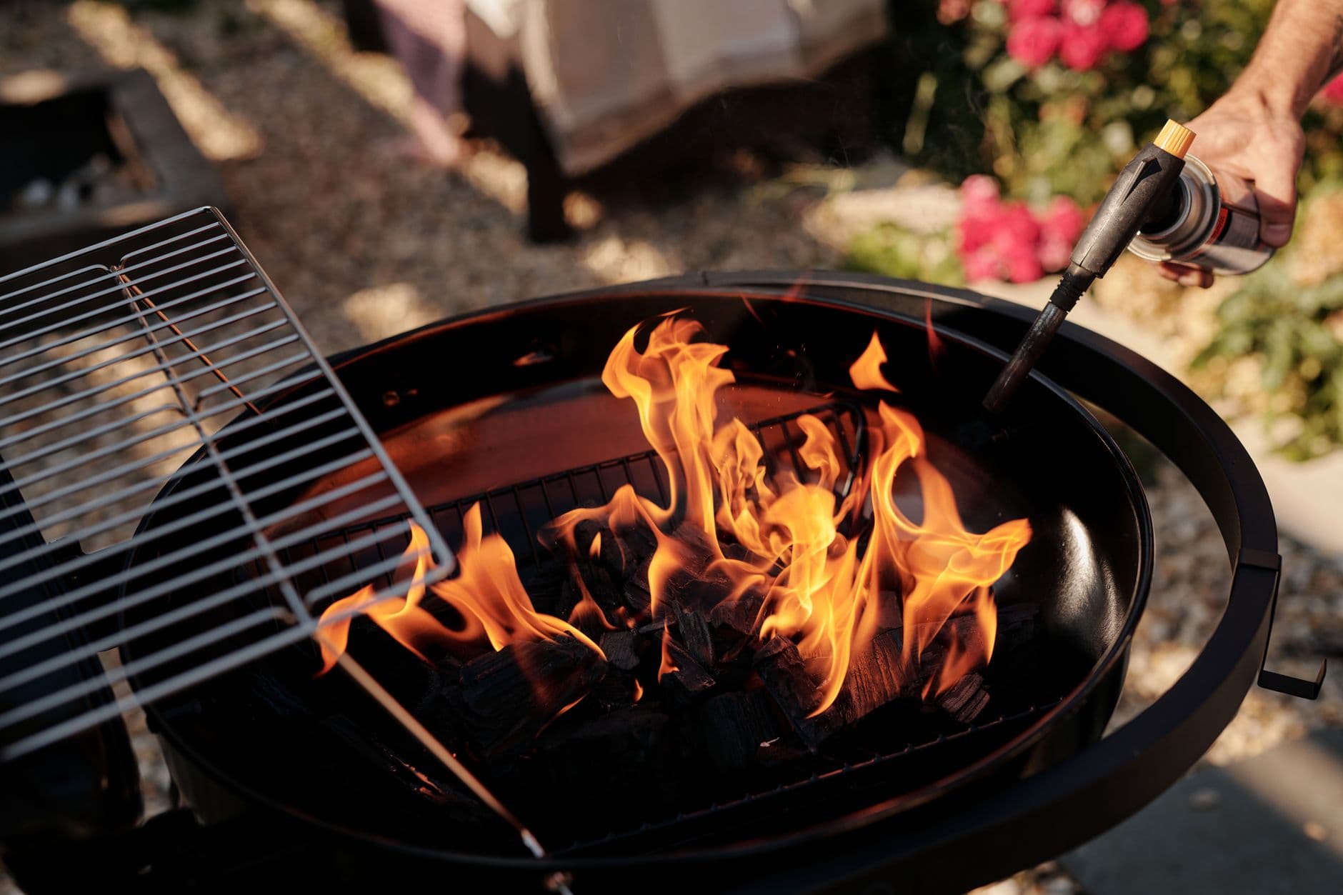 A charcoal grill ignited with flames using a torch. Perfect for outdoor barbecues. — carbón o eléctrica: cuál te conviene